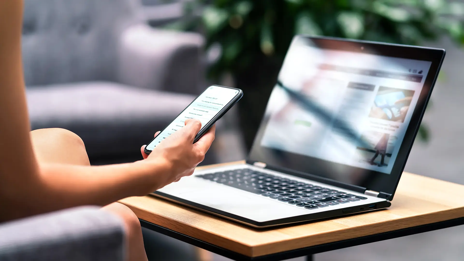Photo of woman at a cafe reviewing a website on her computer and mobile device for the header image